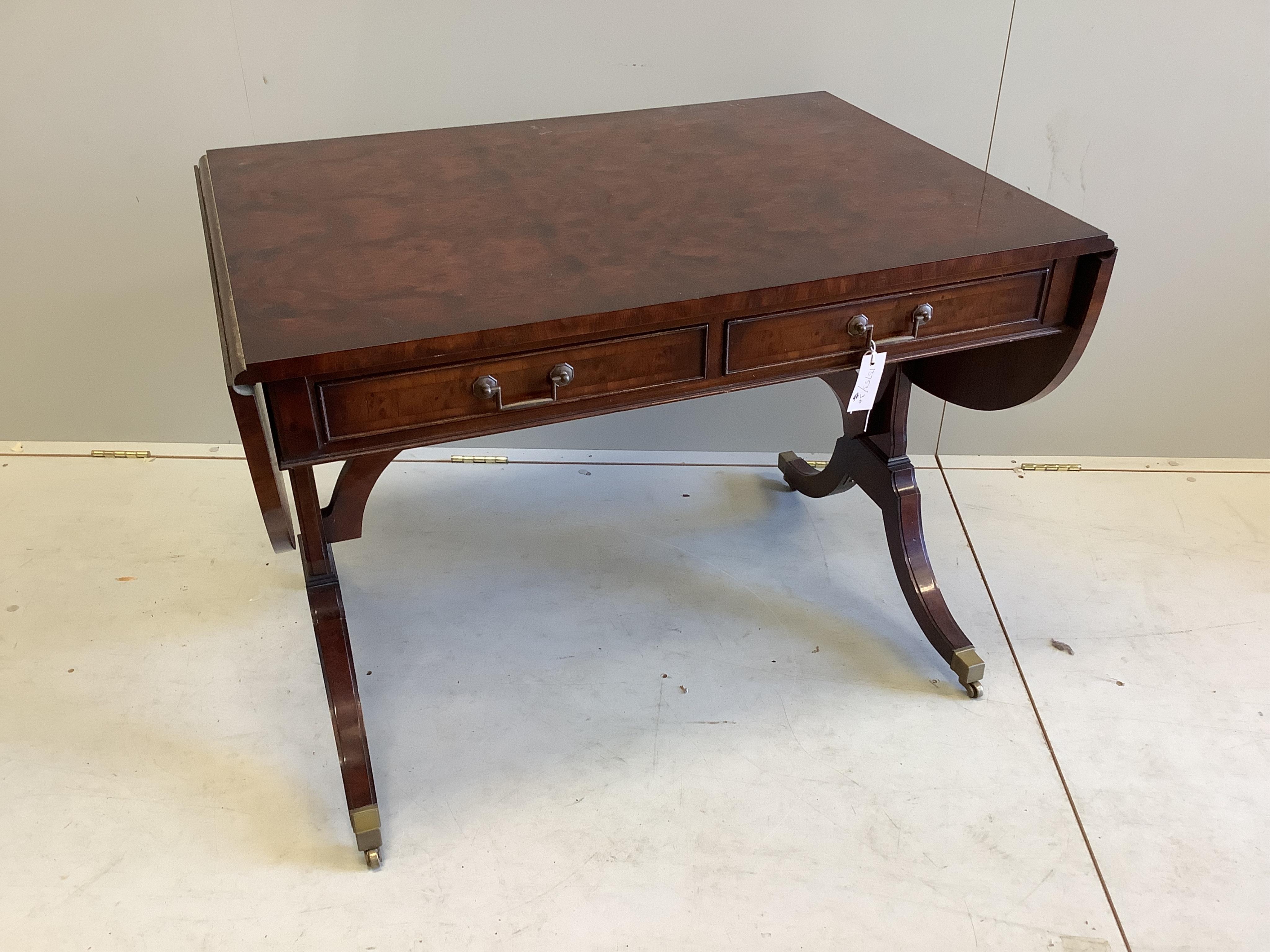 A Bevan Funnell Regency style burr yew and walnut sofa table, twin flaps and two frieze drawers, on plain end standard splayed legs and brass castors, width 150cm extended, depth 66cm, height 70cm